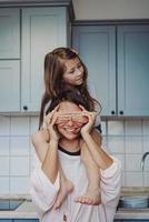 beautiful little daughter piggybacking on her happy mother photo