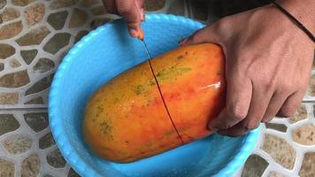cut papaya fruit with kitchen pesos. video