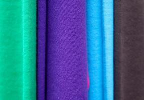 Detailed close up view on samples of cloth and fabrics in different colors found at a fabrics market photo