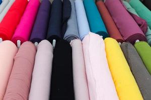Detailed close up view on samples of cloth and fabrics in different colors found at a fabrics market photo