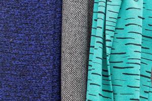Detailed close up view on samples of cloth and fabrics in different colors found at a fabrics market photo
