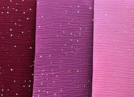 Detailed close up view on samples of cloth and fabrics in different colors found at a fabrics market photo
