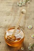 Honey in the Glass bowl on the wooden background. photo