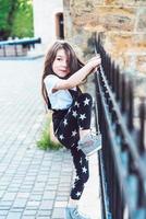 Little girl playing at fence photo