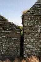 Two old, stacked-stone buildings nestled close together in Orkney, Scotland. photo