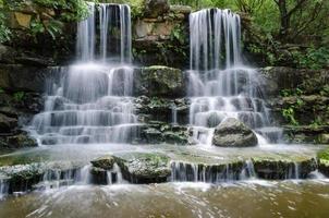 Water from twin waterfalls cascading into a pool. photo