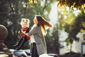 Mother and little daughter playing in a park photo