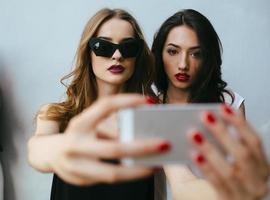 Two girlfriends taking a selfie photo