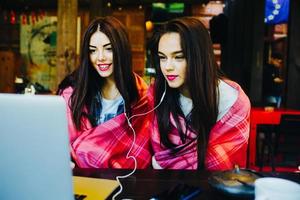 two girls watching something in laptop photo