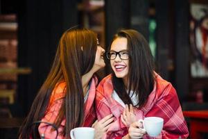 Two young and beautiful girls gossiping photo