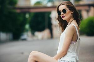 beautiful girl in sunglasses sitting photo