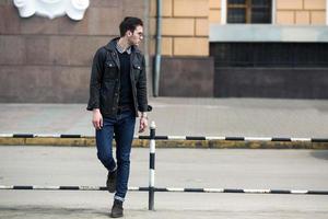 A man dressed in jeans on the background of the old city photo