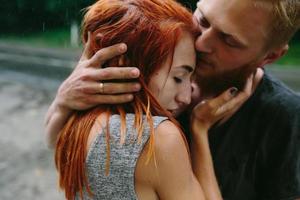 beautiful couple hugging in the rain photo