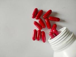 Red pills, red vitamins, red pills on a warm white background, look clean. Vit B. photo