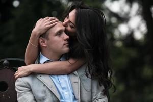 joven pareja europea abrazados en un banco del parque foto