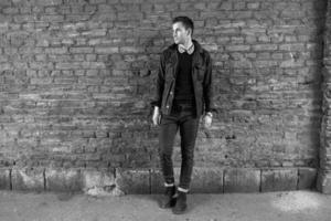 Male model in jeans on the background of a brick wall photo