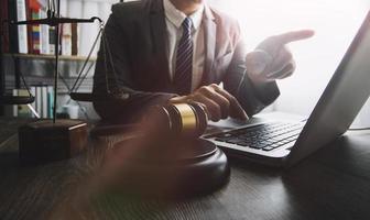 Business and lawyers discussing contract papers with brass scale on desk in office. Law, legal services, advice, justice and law concept picture with film grain effect photo