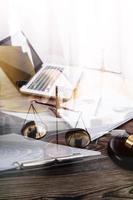 Justice and law concept.Male judge in a courtroom with the gavel, working with, computer and docking keyboard, eyeglasses, on table in morning light photo