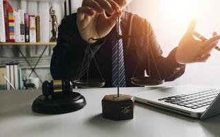 Business and lawyers discussing contract papers with brass scale on desk in office. Law, legal services, advice, justice and law concept picture with film grain effect photo