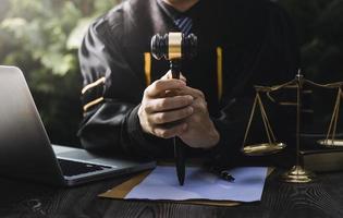 Business and lawyers discussing contract papers with brass scale on desk in office. Law, legal services, advice, justice and law concept picture with film grain effect photo