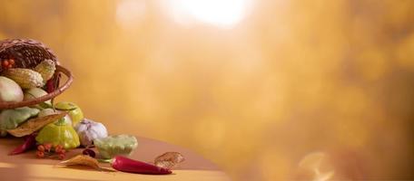 banner de otoño con composición de bodegones hecha de cesta y verduras, hoja de otoño sobre fondo con luz solar y bokeh. copie el espacio foto