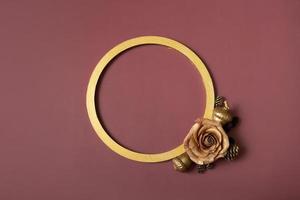 anillo dorado y rosa dorada sobre un fondo marrón. endecha plana, vista superior, espacio de copia foto