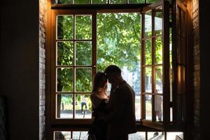 Young couple in love standing by the window photo