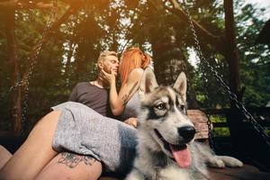 beautiful couple together with dog on a swing photo