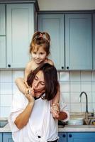 beautiful little daughter piggybacking on her happy mother photo