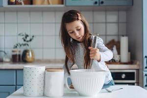 niña cocina en la cocina foto