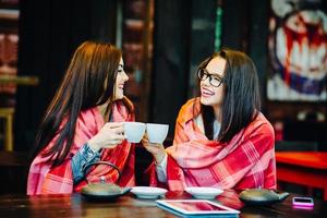 Two young and beautiful girls gossiping photo