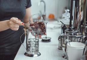 Pour dry tea leaves into the glass container of the tea press maker photo