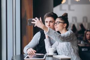 A guy and a girl are sitting together in a cafe. photo