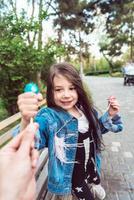 niña sentada en un banco con dulces foto