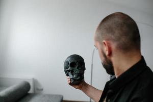 bearded man holding skull photo