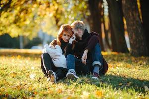 young family and newborn son in autumn park photo