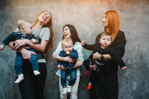 Three moms with their children posing on camera photo