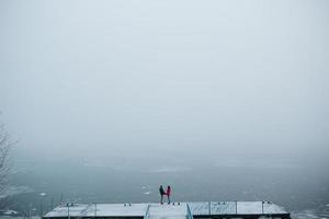 beautiful young couple standing on a pier photo