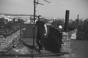 The man in the authentic boots and jeans selvedge on the roof of the building in the old town photo