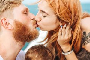 Mom and Dad kiss. Happy family on vacation photo