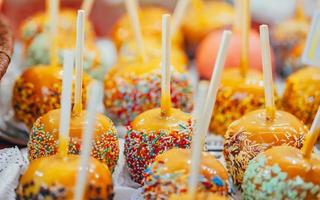 Apples in caramel and sprinkles. Street food. photo