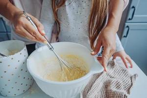 mamá le enseña a su pequeña hija a cocinar foto