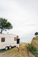 Handsome, young guy posing on a wild seashore photo