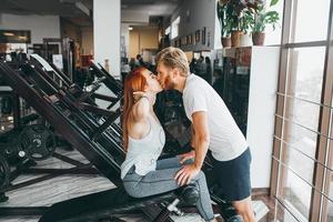 chico besa a la novia en el entrenamiento en el gimnasio foto