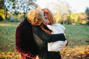 familia joven e hijo recién nacido en el parque de otoño foto