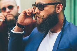 Two bearded businessman looking at phone photo