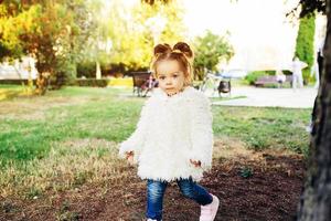 Cute little girl is playing outdoors photo