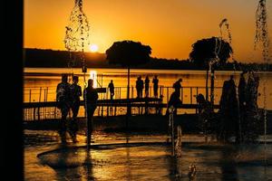 people spend leisure time on the river bank photo