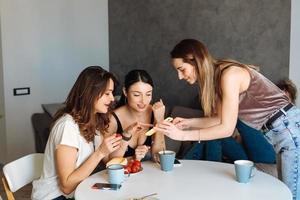 three woman friends breakfast in the kitchen photo