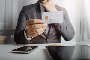 technology, people and online shopping concept - happy smiling man with tablet pc computer and credit card at home photo